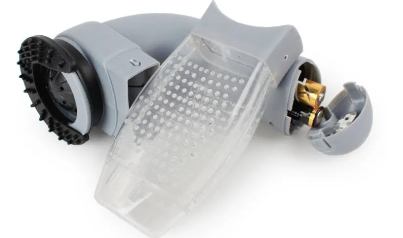 Grey handheld electric pet hair remover brush with soft rubber head, shown removing fur from upholstery.