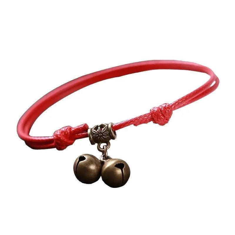 Nylon rope dog collar with brass bell on a black background, showing the adjustable rope and metal hardware.