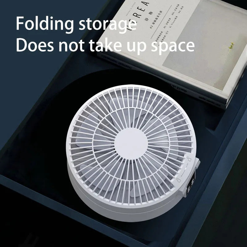 White portable USB rechargeable folding desk fan with remote control on wooden surface