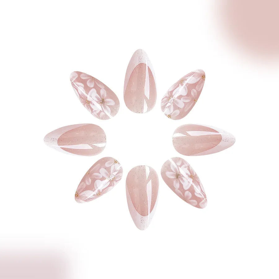 Short almond artificial nails with French style glitter flower decoration in C625 colour
