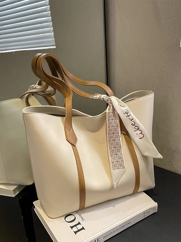 Soft large capacity tote bag with crossbody strap in khaki colour showing outer pocket and sewing line detail