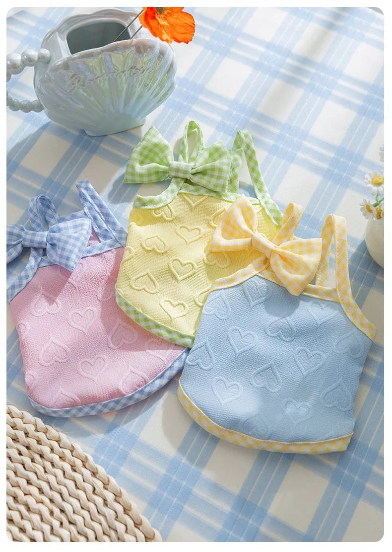 Small dog wearing heart bow suspenders vest in blue with elastic sides