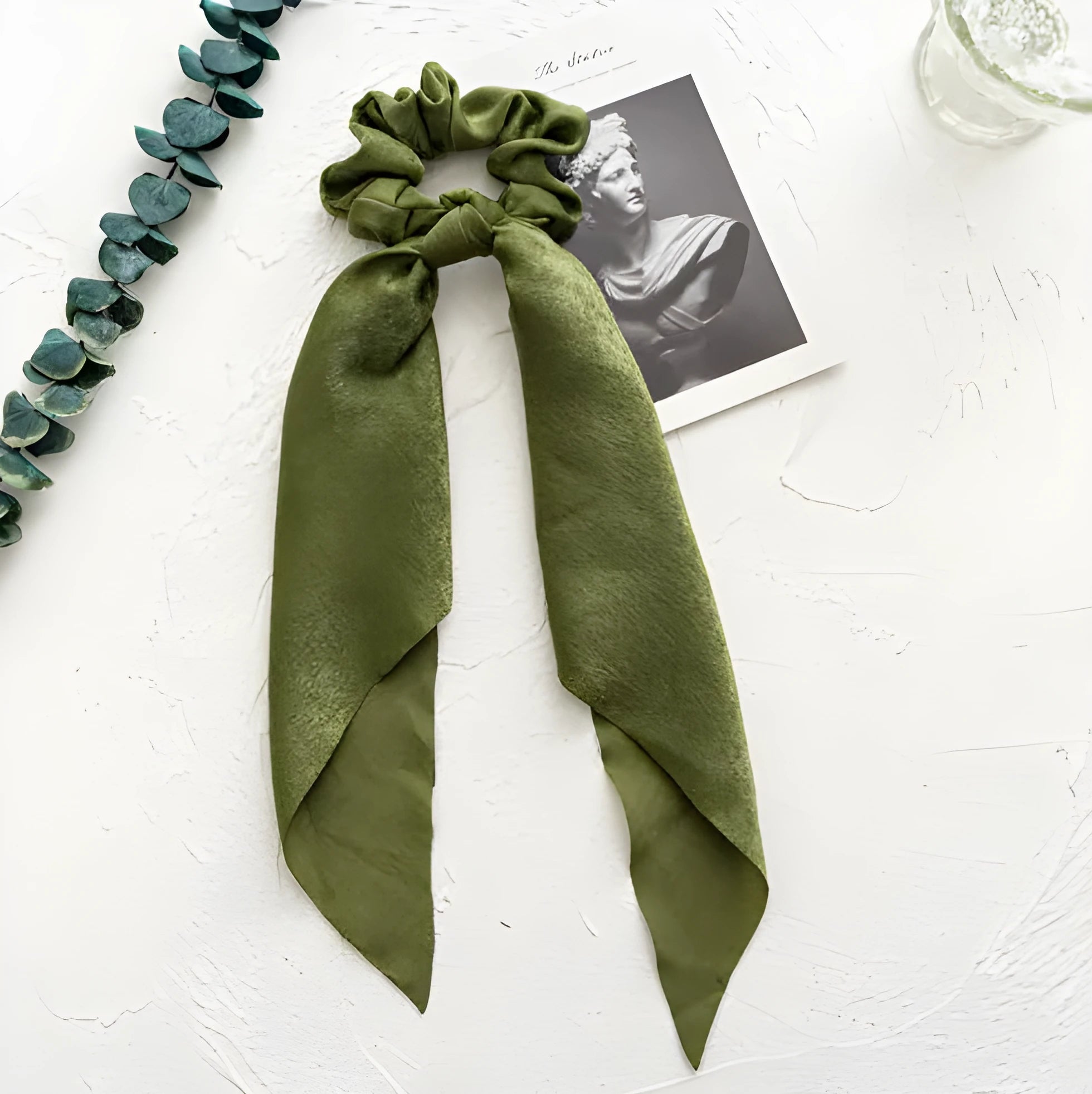 Spring dark green cloth hair accessory shaped as a large intestine ring, shown as a hair band.