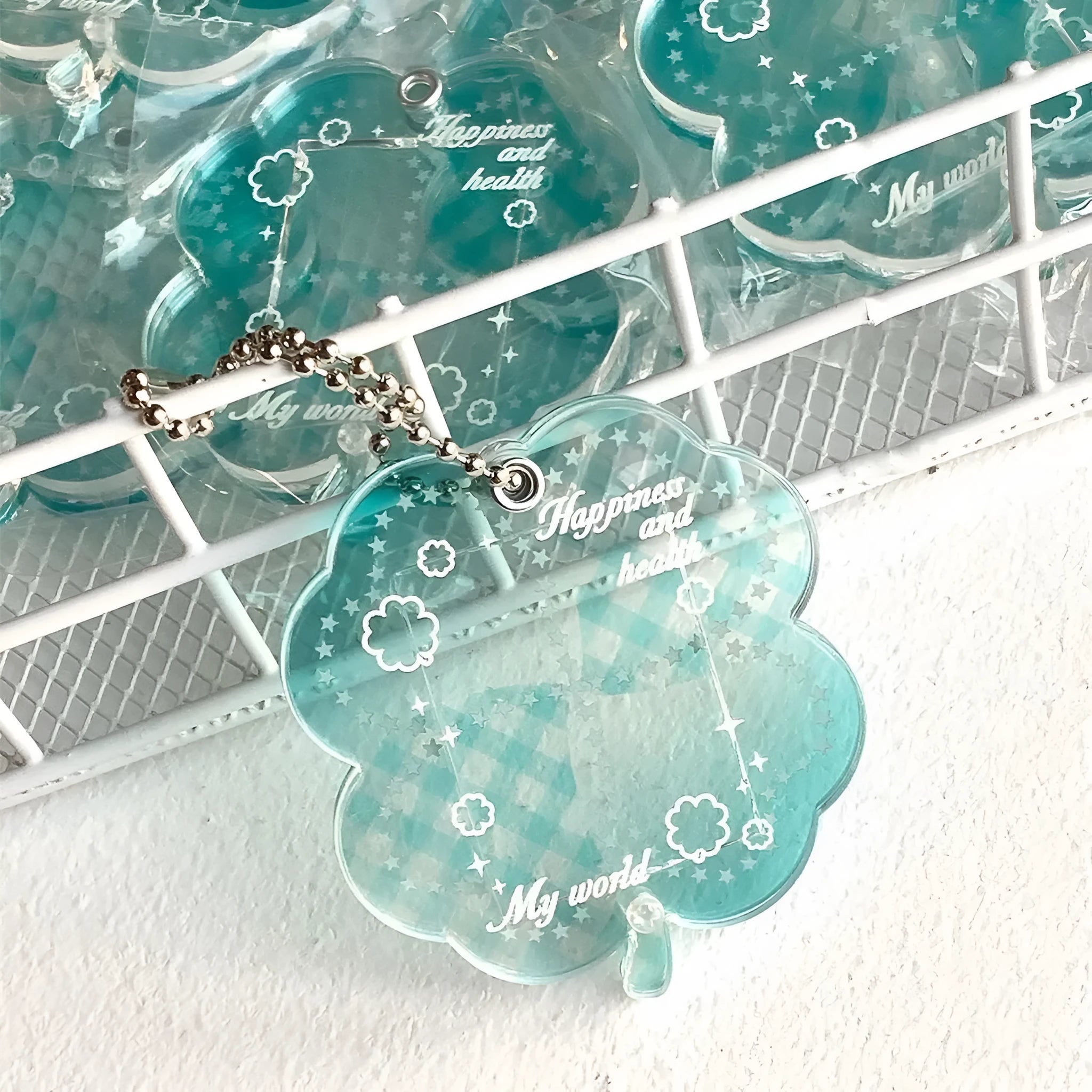 Acrylic four-leaf clover pendant charm for phone or keychain in blue or green colours.
