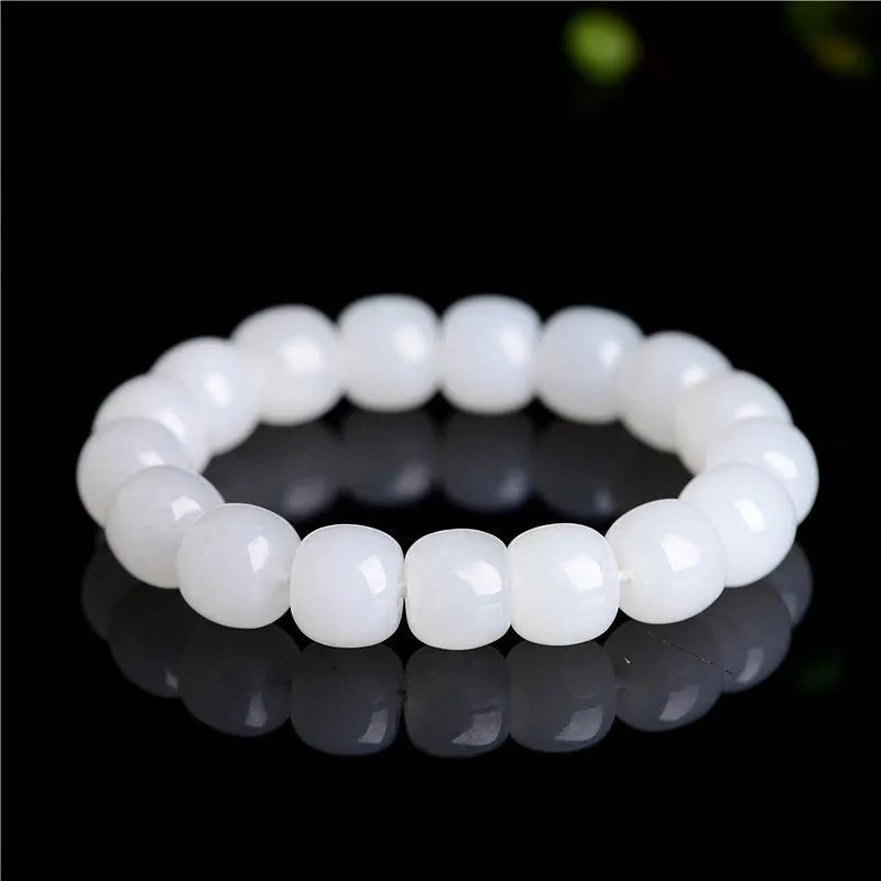 White Hetian jade barrel bead bracelet for men and women on a plain background.