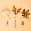 Three small flying insect cat toy replacement heads with steel wire stems on white background
