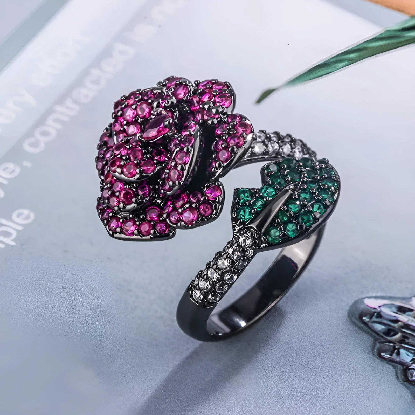Geometric black gold flower ring with simulation red corundum centrepiece on female hand