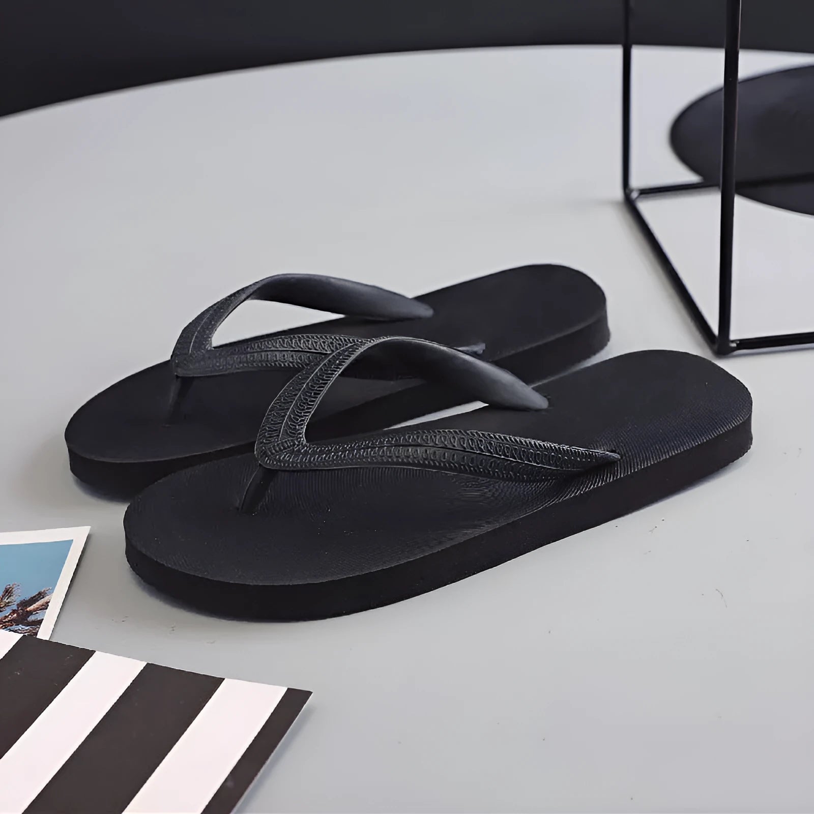 Men's rubber flip-flops in green with a fish label on the strap, showing the non-slip tread pattern on the sole.