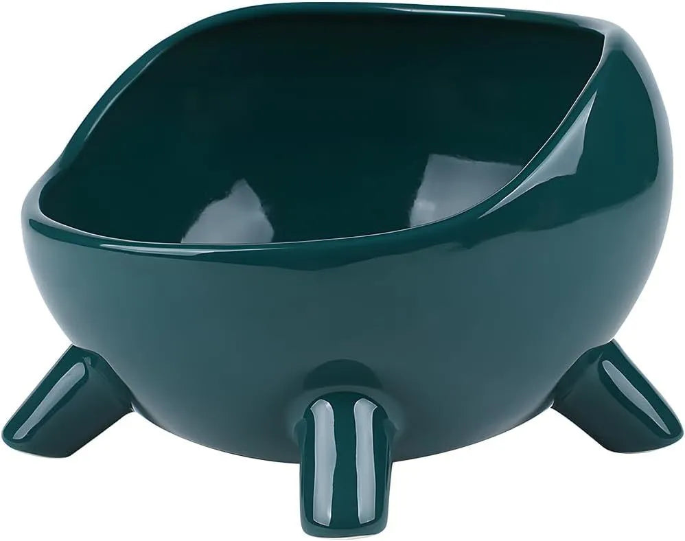 Green ceramic cat food bowl with four legs and rounded arc design on wooden floor