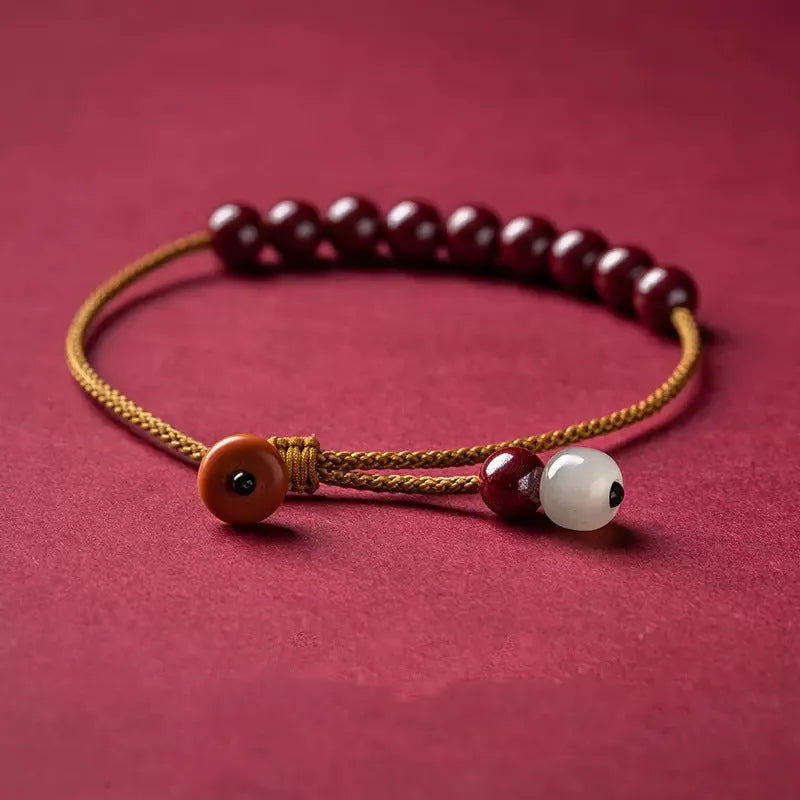 Hand-woven cinnabar geometric bracelet showing raw ore material texture and adjustable design