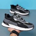 Men's colour block mesh running sneakers in black, grey, and white on a plain background.