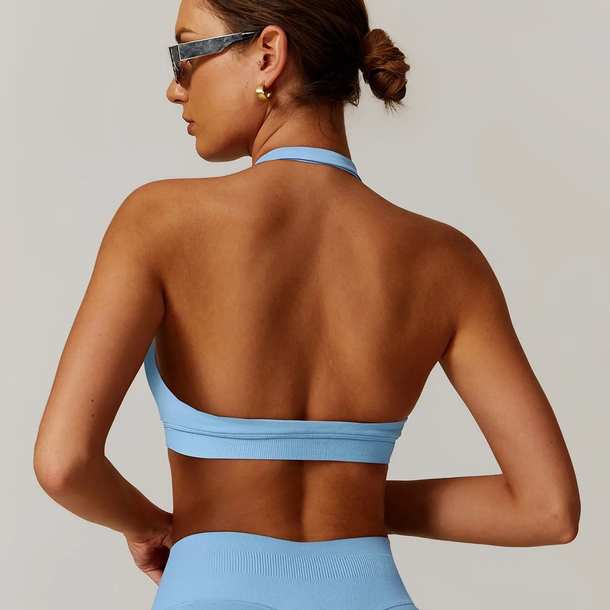 Women's black halter neck sports bra on a mannequin, showing medium support and removable padding.