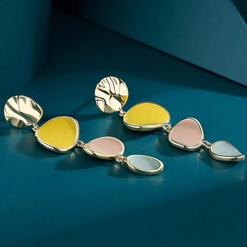 A pair of disc-shaped alloy earrings with a Morandi three-colour dripping oil finish on a sterling silver needle post.