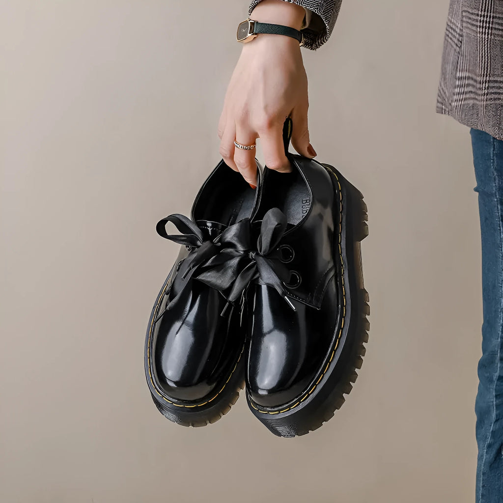 Women's black leather shoes with thick soles, ribbon cross-straps, and lace closure