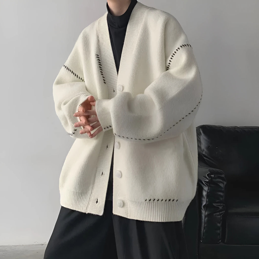 Women's loose fit black knitted cardigan top coat with long sleeves, hanging on a hanger.
