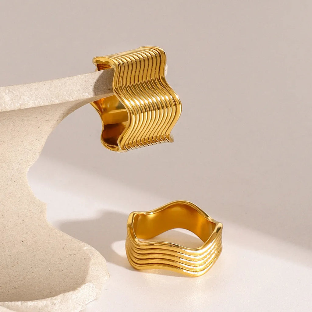 Stainless steel women's ring with geometric wide wave design and electroplated finish.