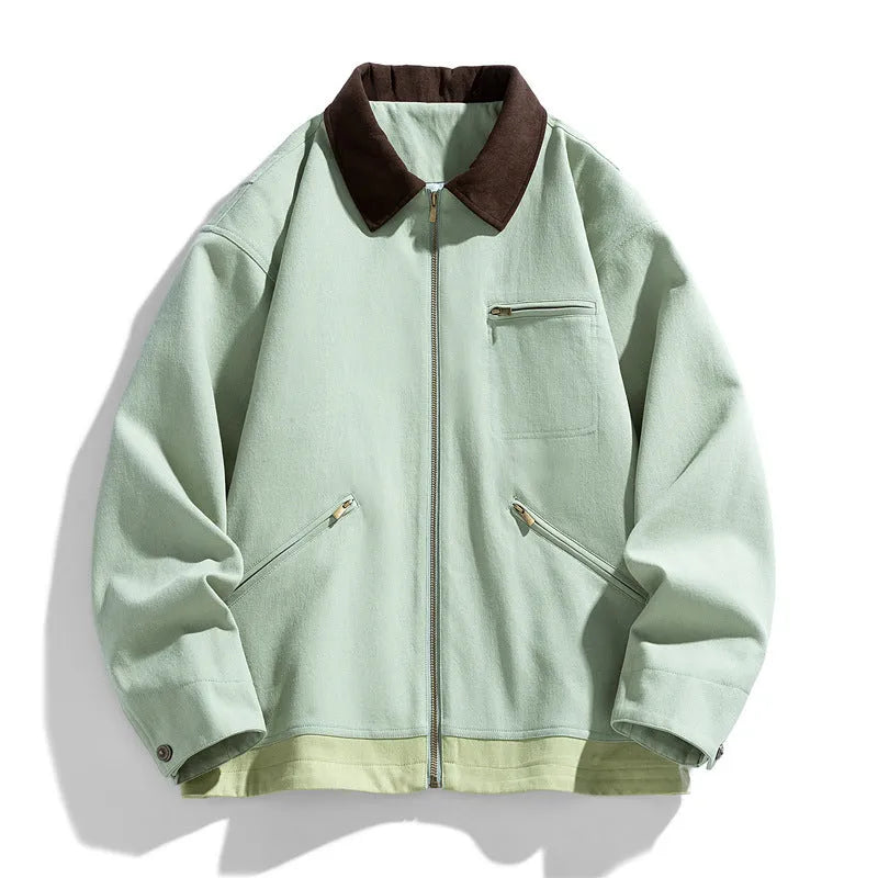 Man wearing a mint green retro-style workwear jacket with dark contrast lapels and side pockets.