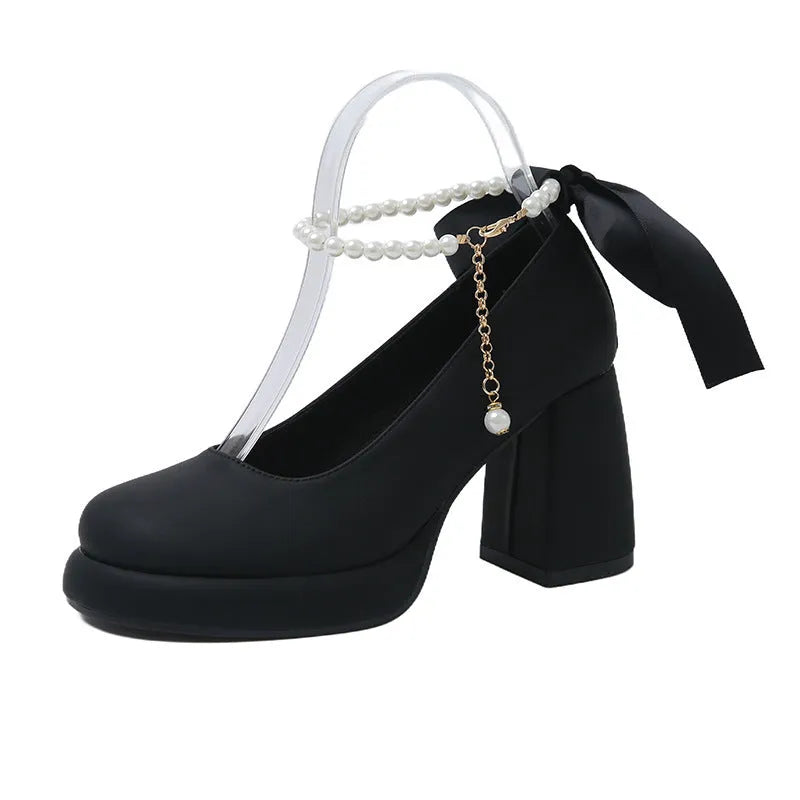 Women's beige Mary Jane shoes with chunky low heel, pearl decoration, and ankle strap buckle on a round toe.