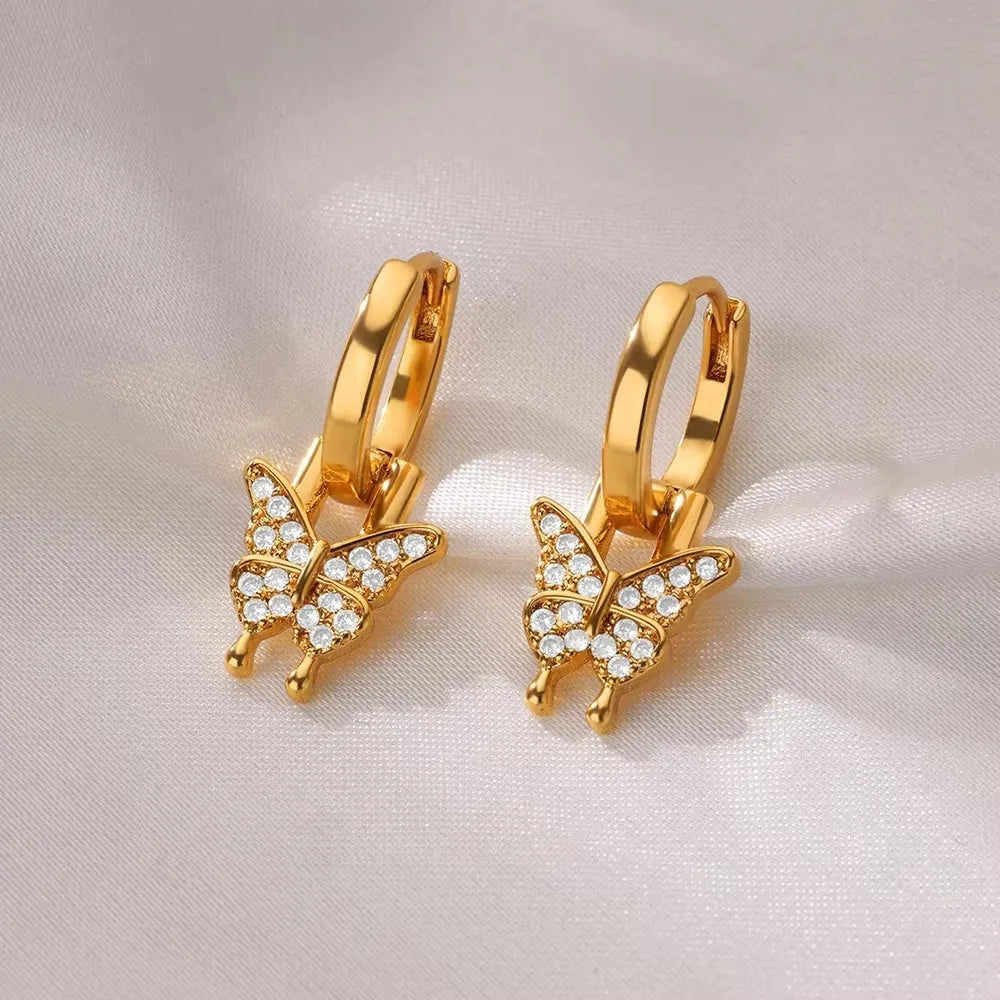 Close-up of women's geometric butterfly drop earrings with heart, star, and bow shapes in copper.