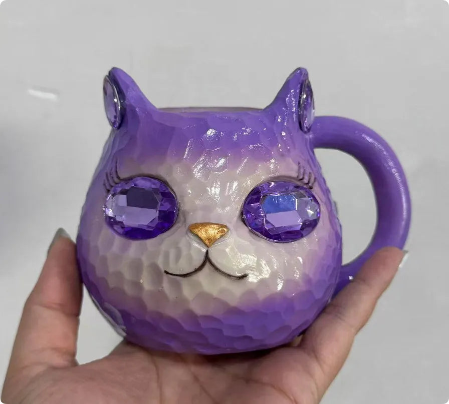 Coloured resin cat cup decoration in purple, green, blue, or pink on a shelf.