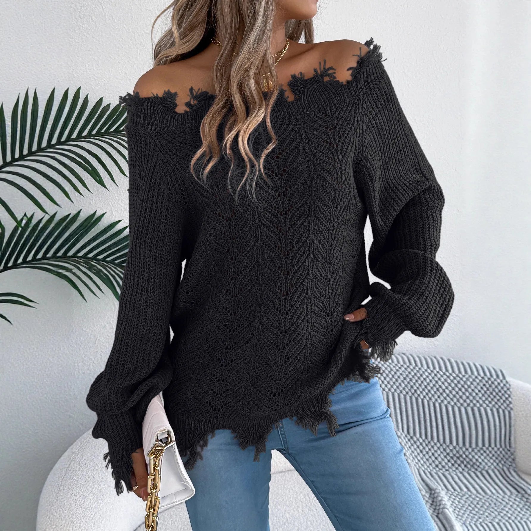 White women's hollow-out knit pullover sweater with long sleeves and an off-the-shoulder neckline.
