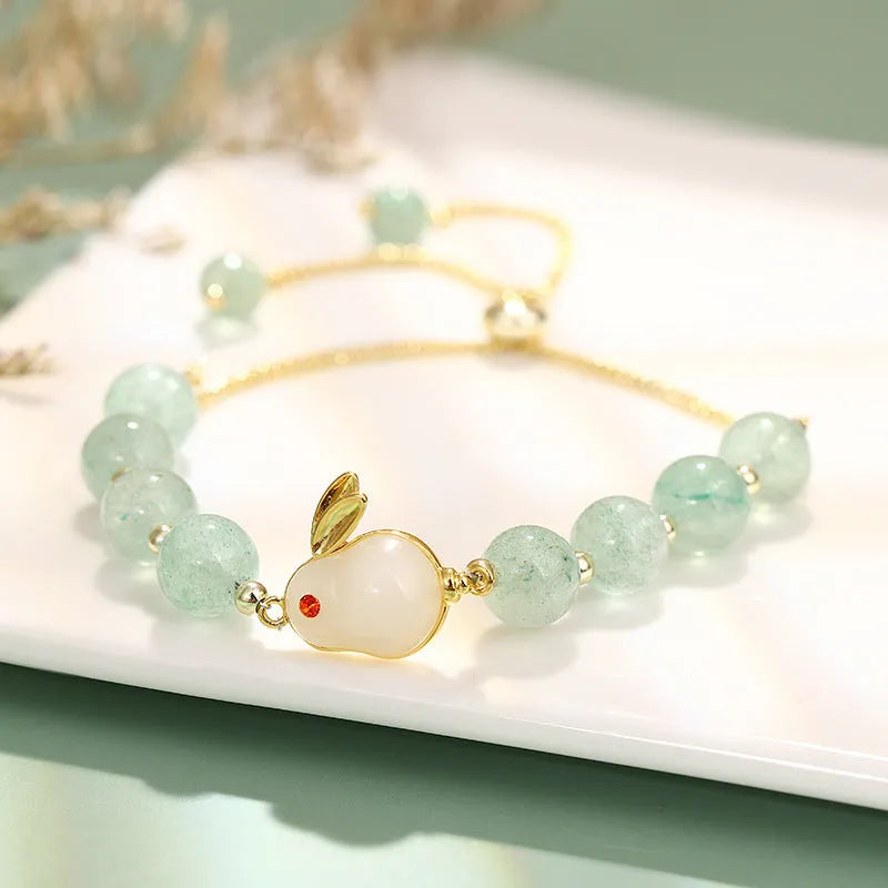 Rabbit charm bracelet with green aventurine or strawberry quartz beads on a gold-coloured adjustable chain.
