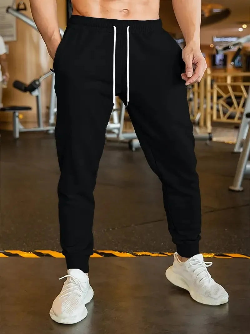 Men's loose-fit casual trousers with an elastic drawstring waist in a neutral colour.