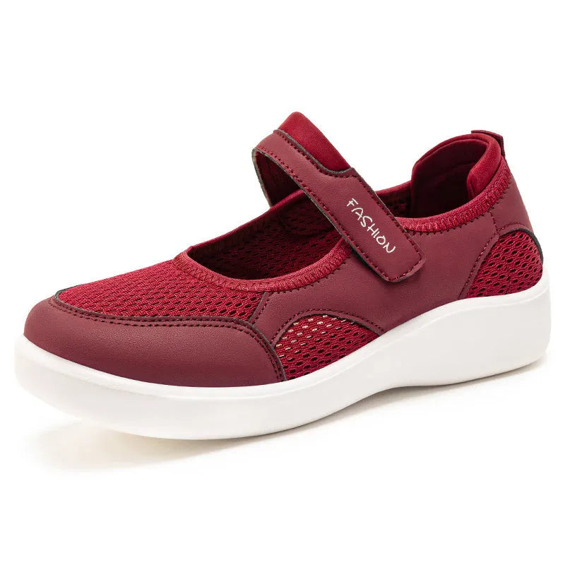 Women's grey mesh slip-on casual shoes with Velcro strap fastening on a flat sole.