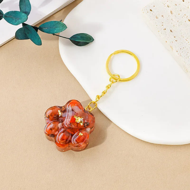 Natural crystal cat's paw shaped pendant on a silver keychain ring, shown in a random colour.