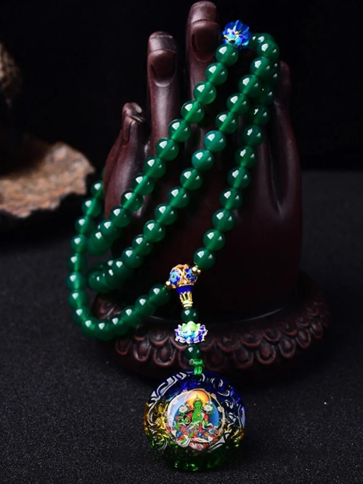 Natural green agate 108-bead bracelet with pendant in Thangka style on a wrist.