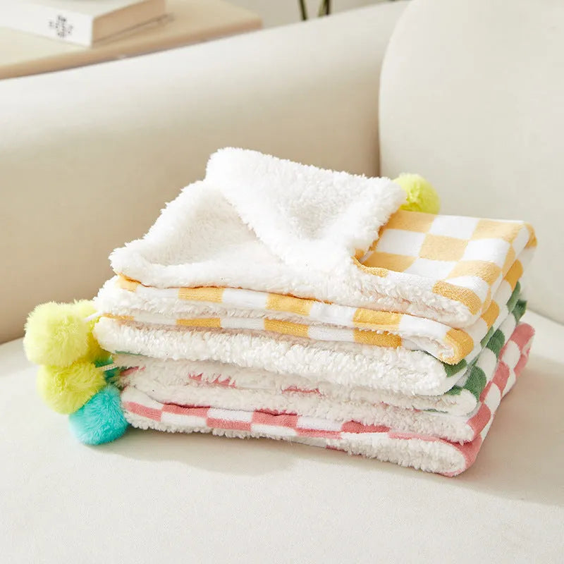 Plaid pattern pet blanket with fur ball trim on soft cotton fleece material for cats and dogs