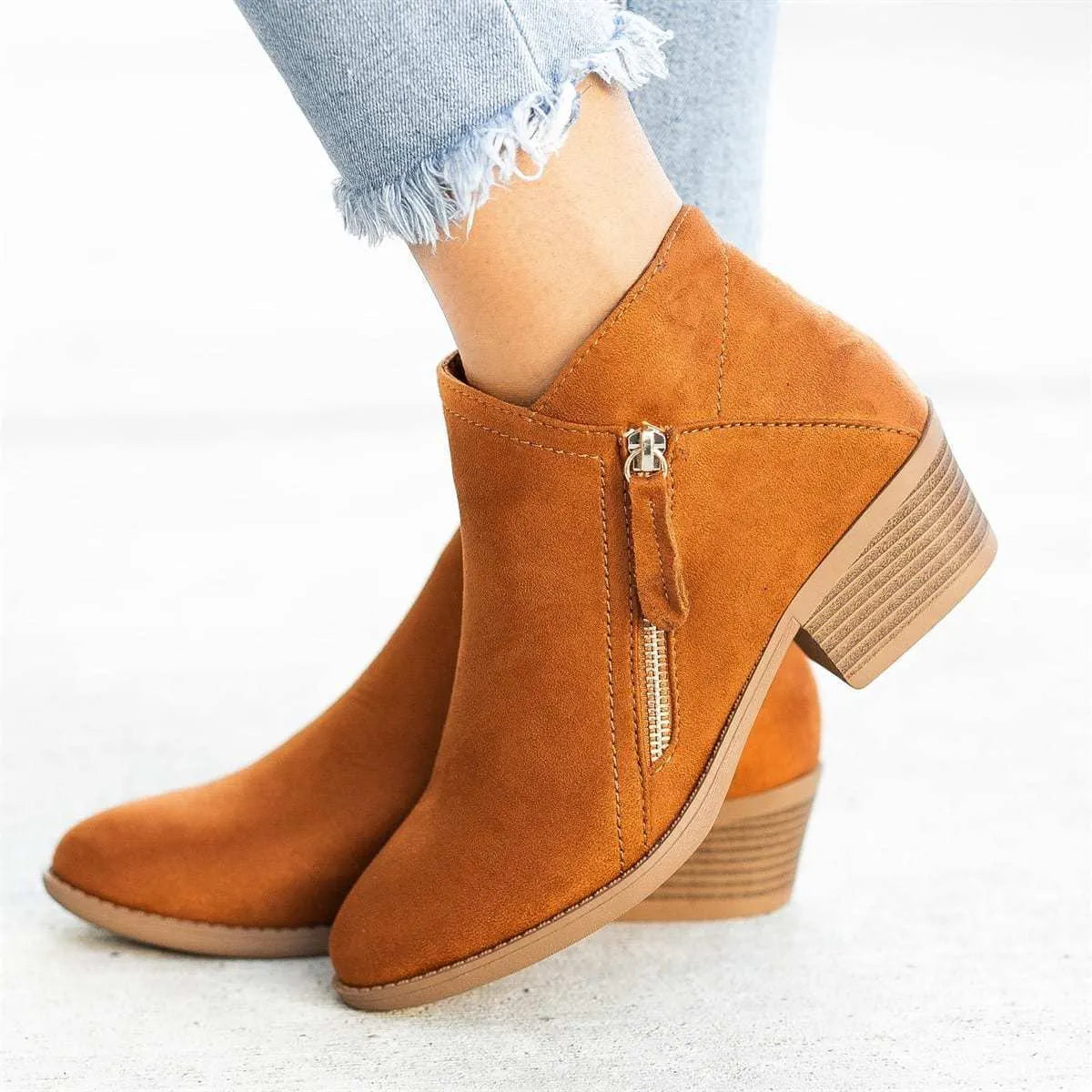 Women's beige suede chunky heel ankle boots with a side zip fastening, shown on a neutral background.