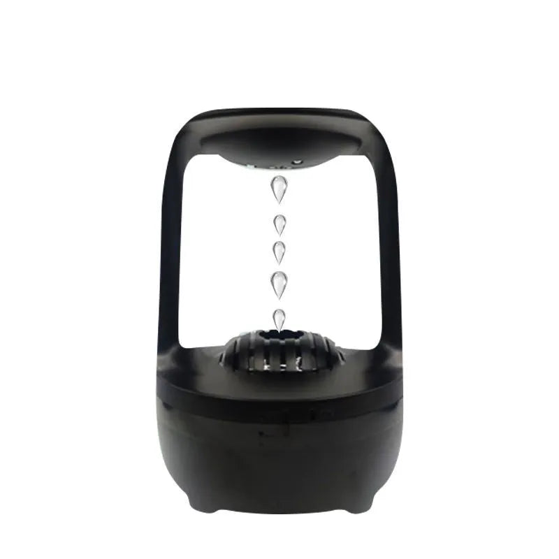 White anti-gravity humidifier on a desk showing water droplets in mid-air backflow, with USB cable.