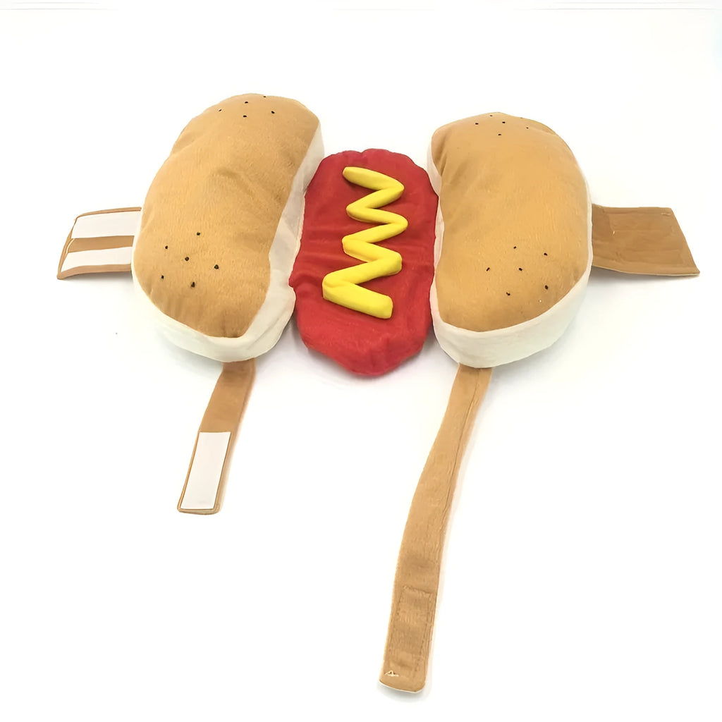 A small dog wearing a plush red and brown hot dog costume suit with mustard detailing.
