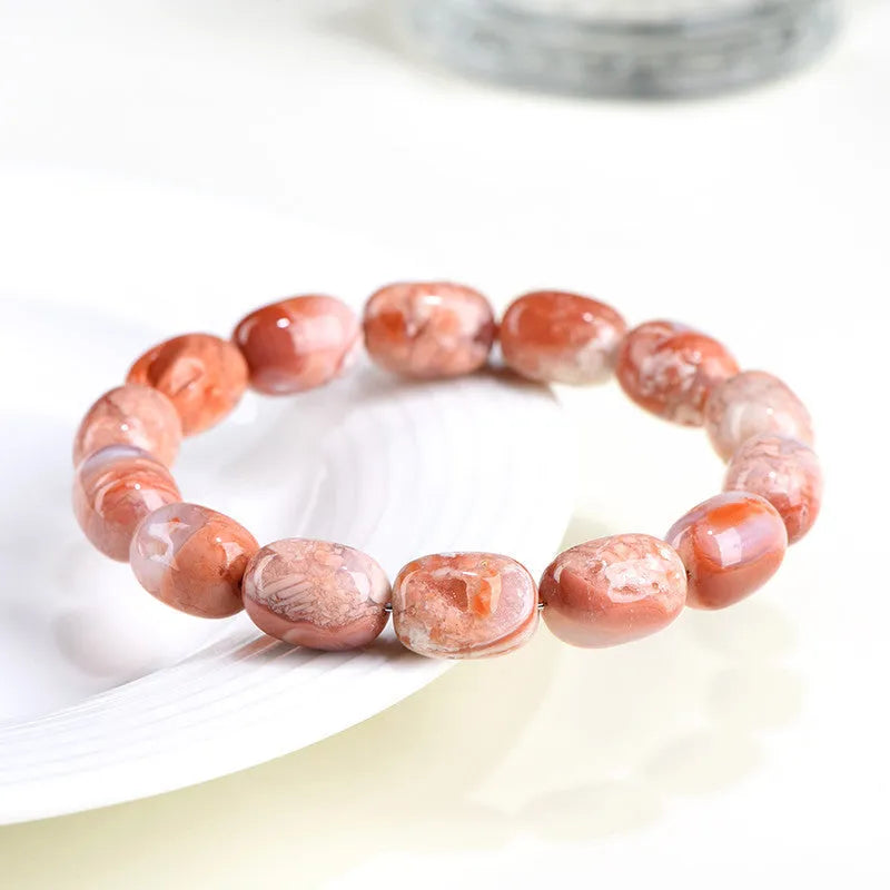 Natural cherry agate bracelet with barrel-shaped beads showing geometric design and Ruyi patterns