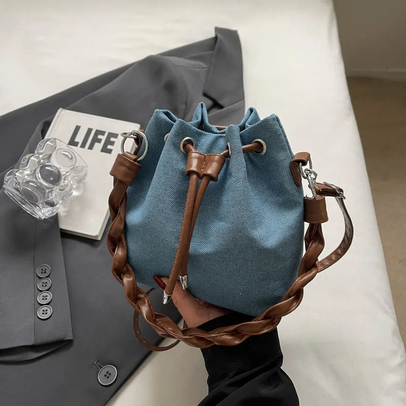 Blue one-shoulder cross body bucket bag with synthetic leather lining and hanging drop ornaments