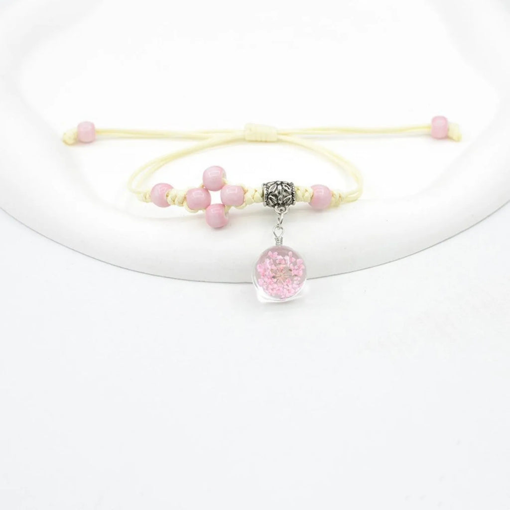Close-up of a hand-woven glass bracelet with large 1.4 cm beads containing real dried flowers in multiple colour options.