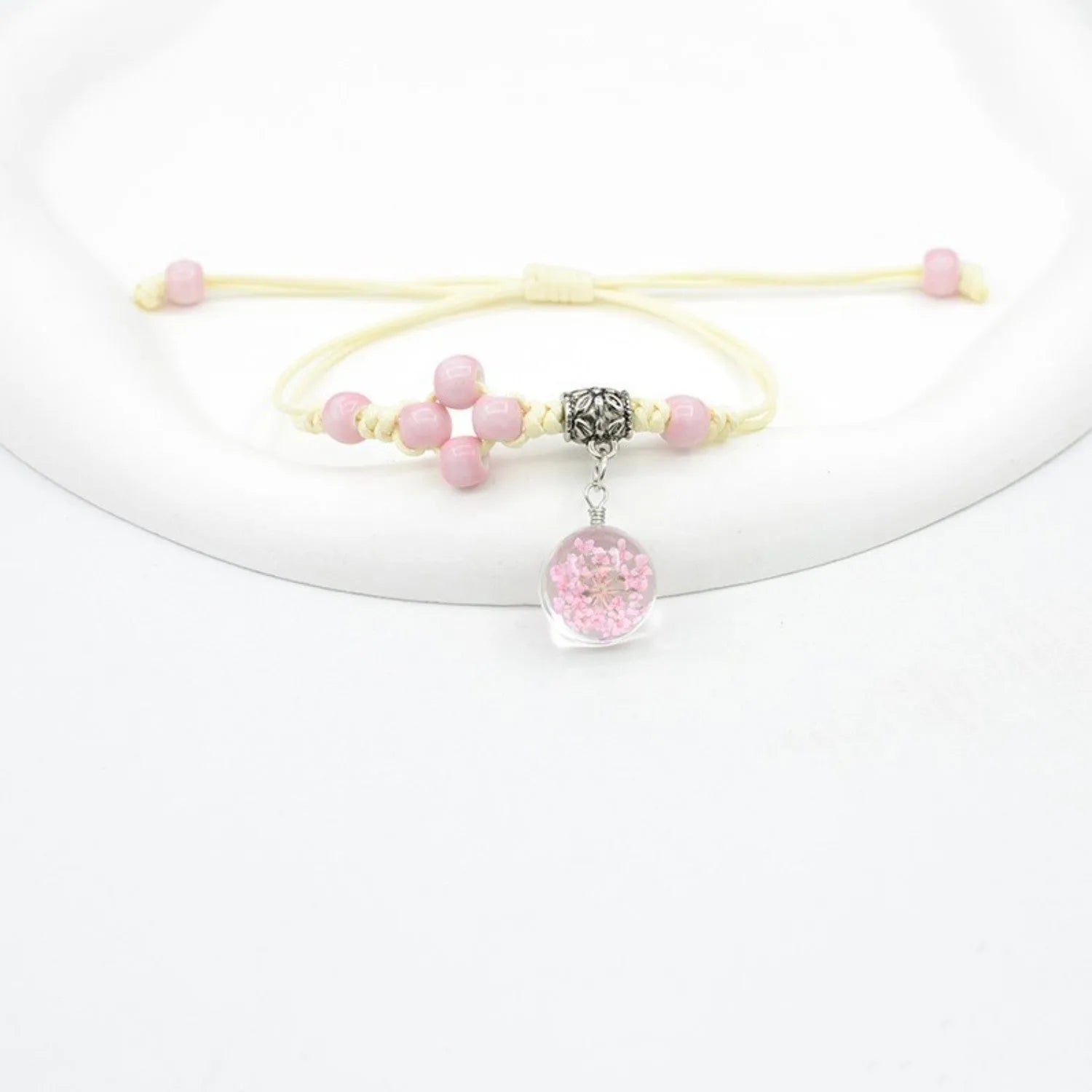 Close-up of a hand-woven glass bracelet with large 1.4 cm beads containing real dried flowers in multiple colour options.
