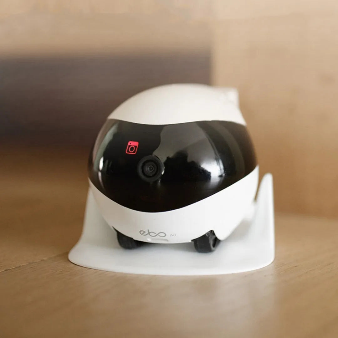 White mobile surveillance robot camera with automatic docking station on wooden floor