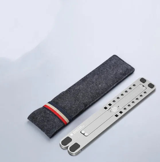 Silver foldable aluminium laptop stand holding a MacBook at an angle, shown next to a backpack.