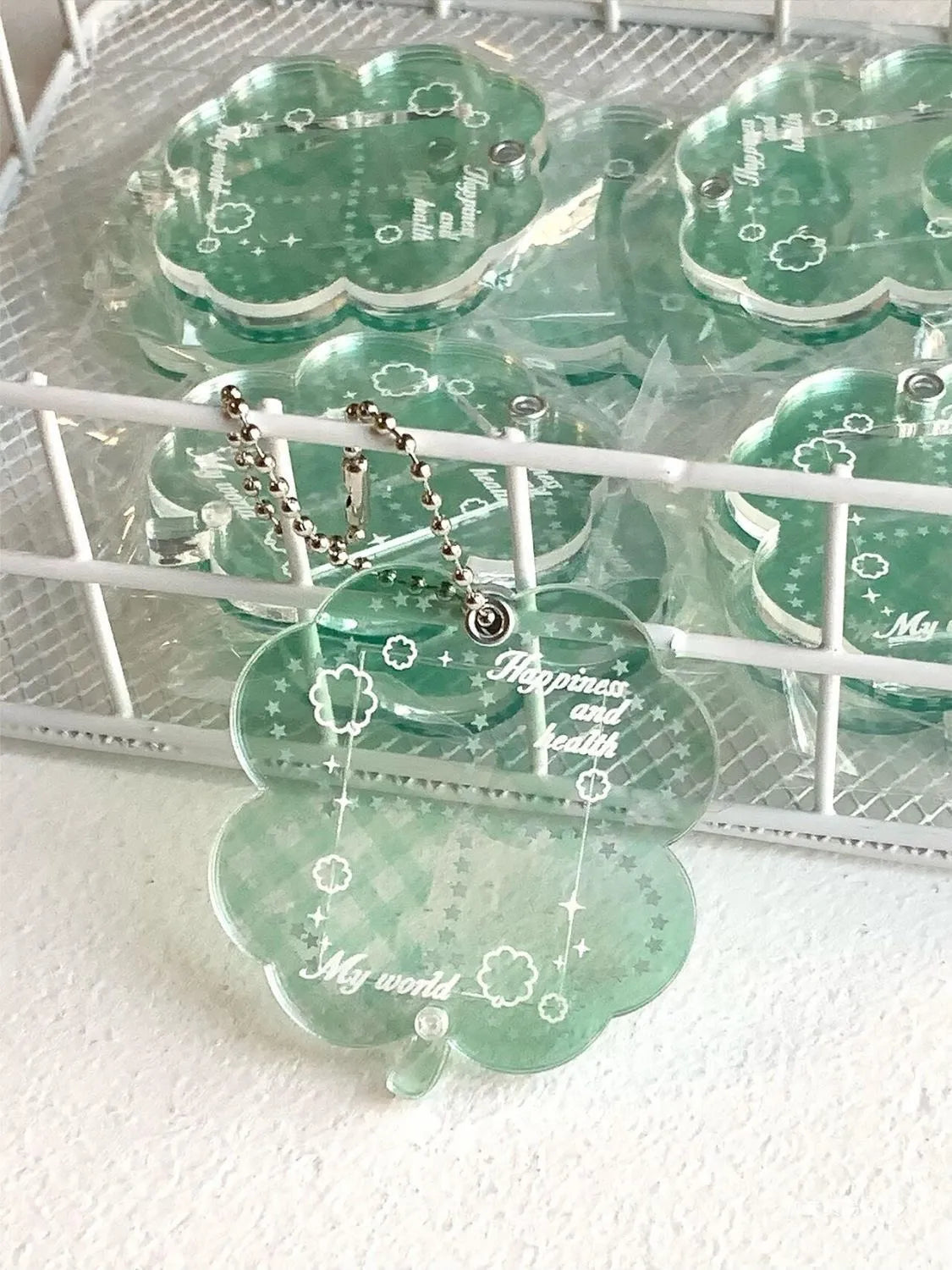 Acrylic four-leaf clover pendant charm for phone or keychain in blue or green colours.