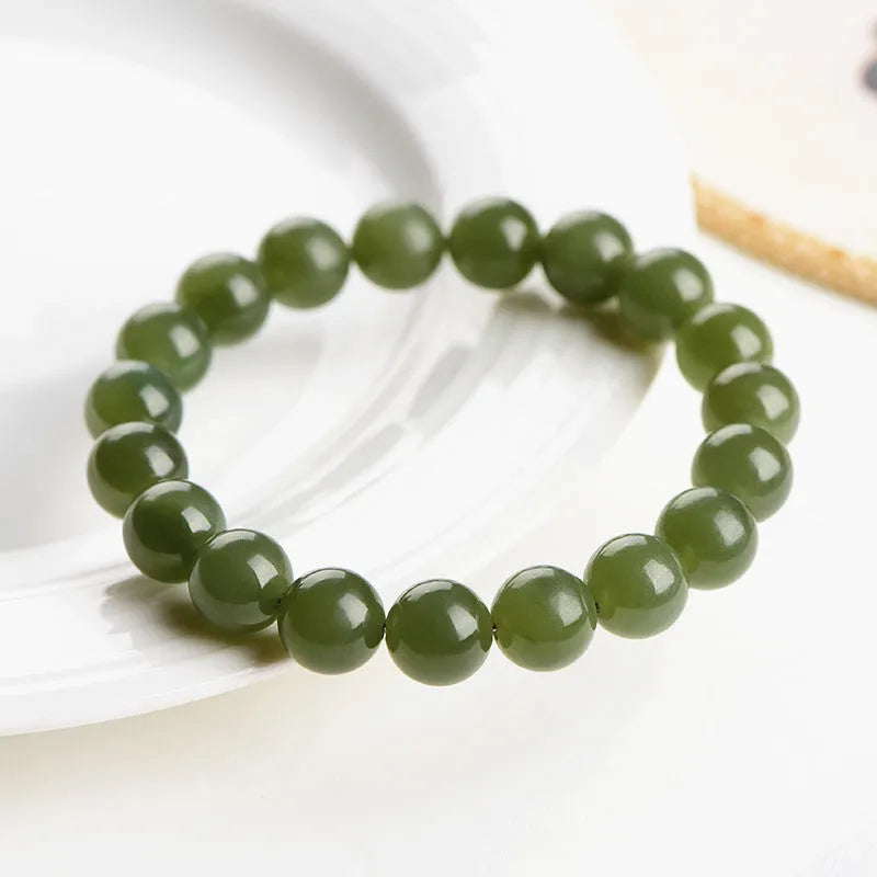 Hetian jade ball bracelet with polished beads in clear water colour on a string.