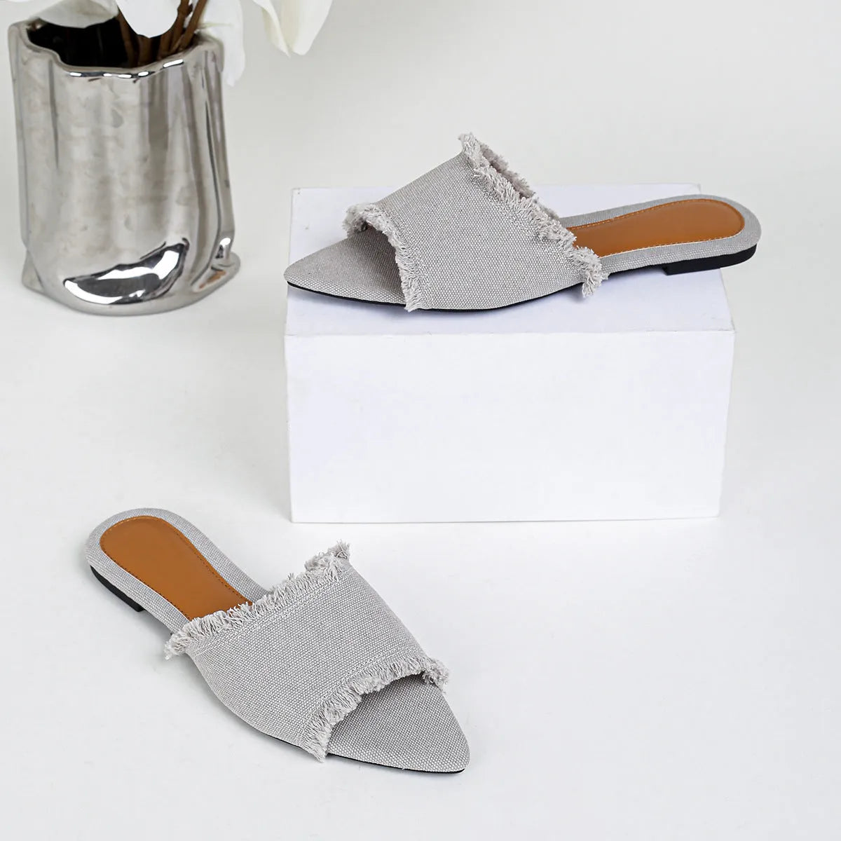 Women's denim flat slippers with tassel detail in multiple colour options showing leather lining and PVC sole