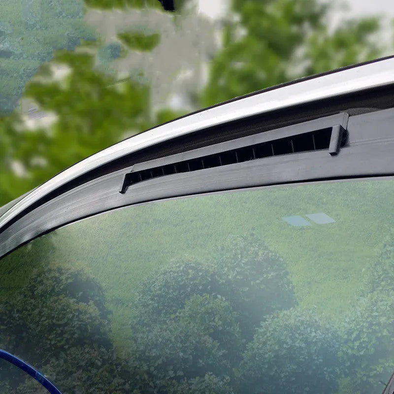 Black and white portable USB-powered car ventilation fan on a car dashboard.