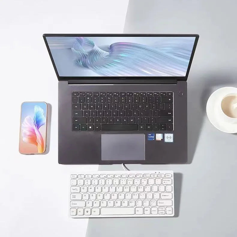 Compact black wired USB keyboard with noiseless keys on a desk.