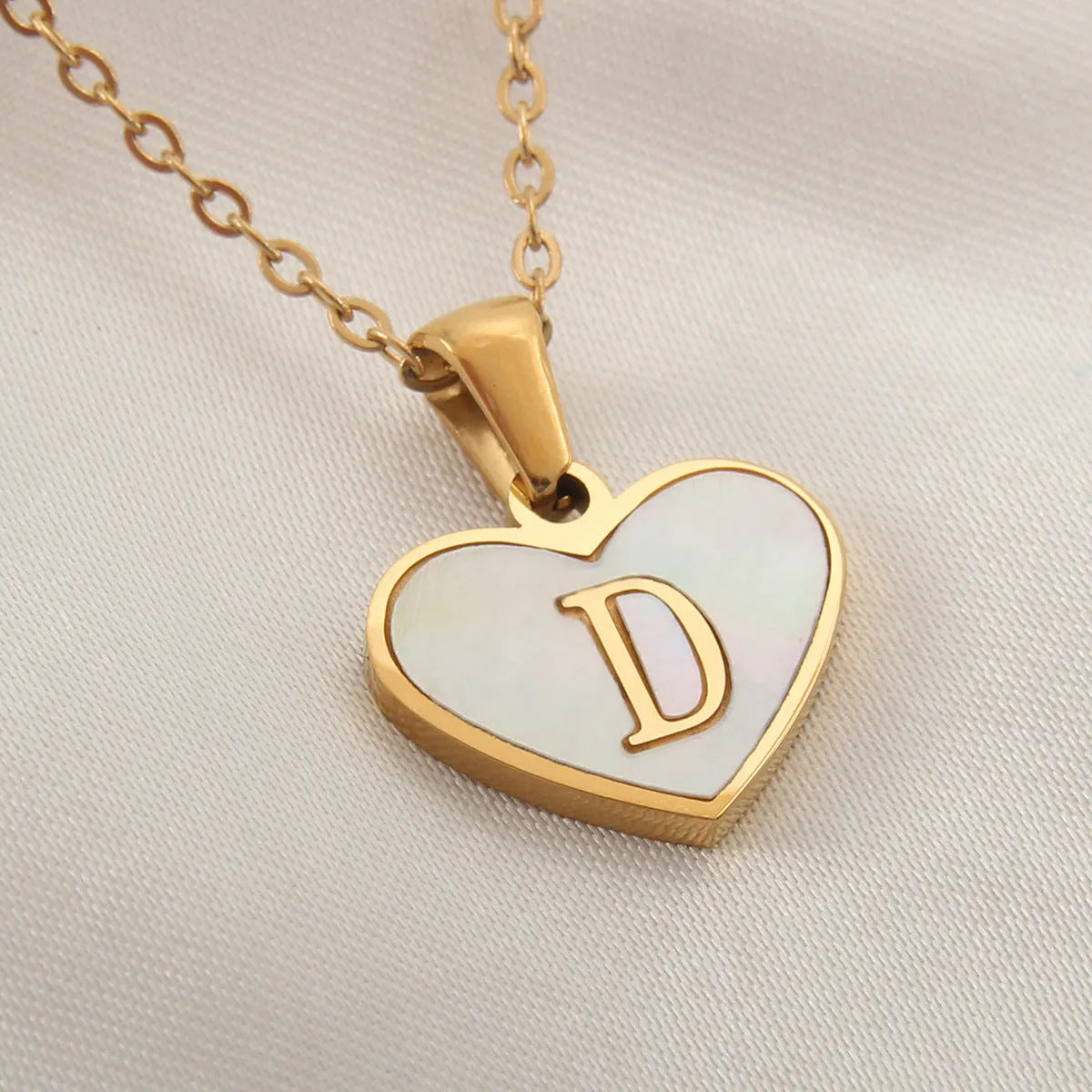 Gold plated heart-shaped necklace with white shell pendant on adjustable stainless steel chain