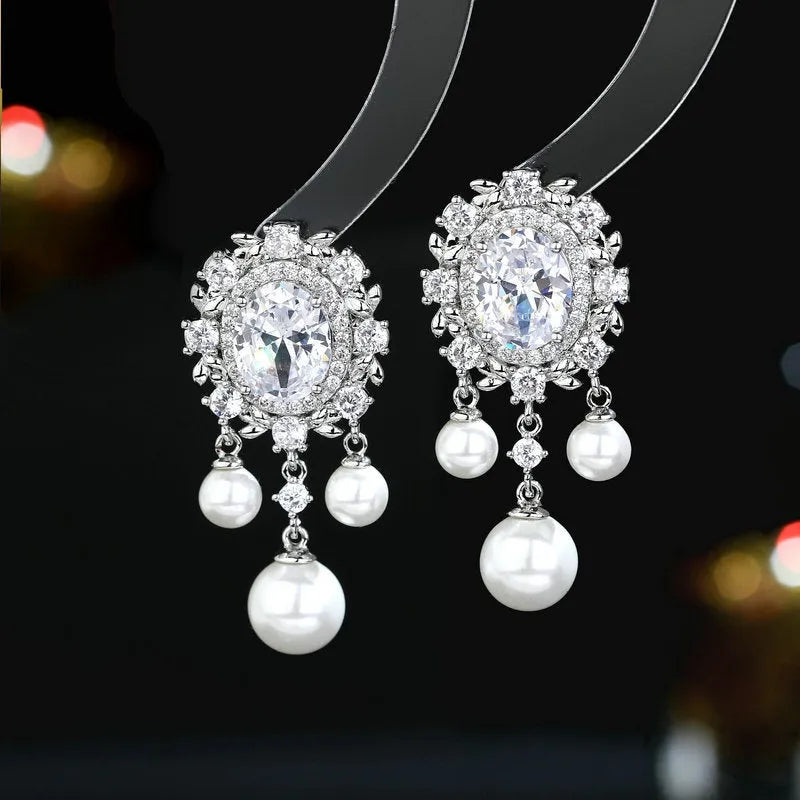 Oval-shaped copper earrings with zircon-inlaid pearls and long decorative tassels in light purple.