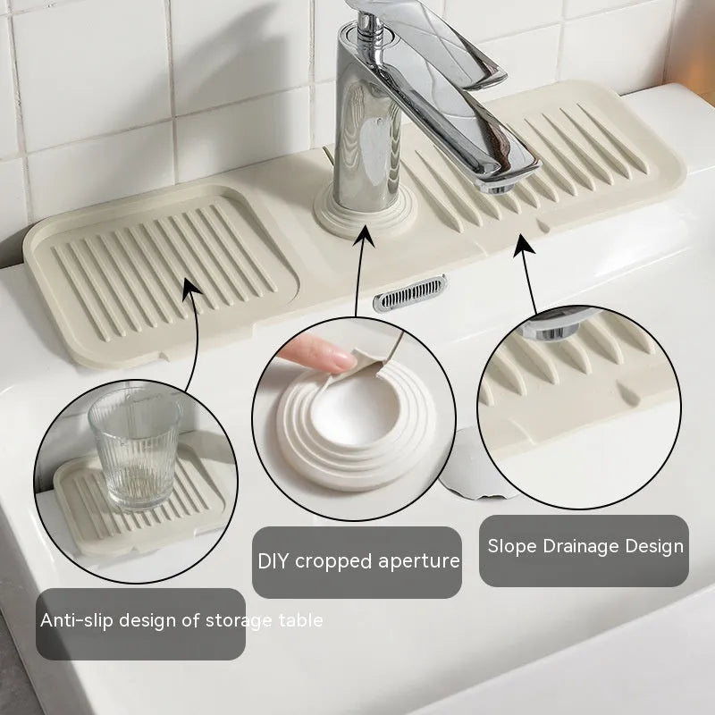 Beige silicone faucet splash guard pad with a sloped design and two circular drain holes, placed under a kitchen tap.