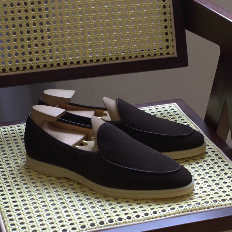 Men's brown genuine leather flat loafers with a low cut and TPR sole on a light background.