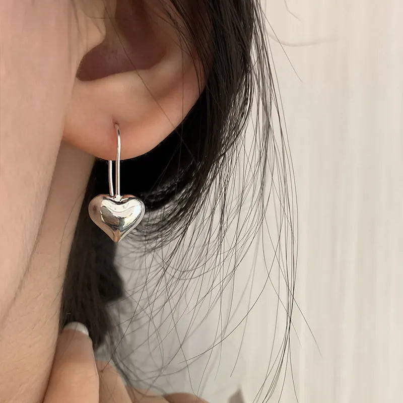 Silver heart-shaped earrings with three-dimensional glossy finish and Korean style design